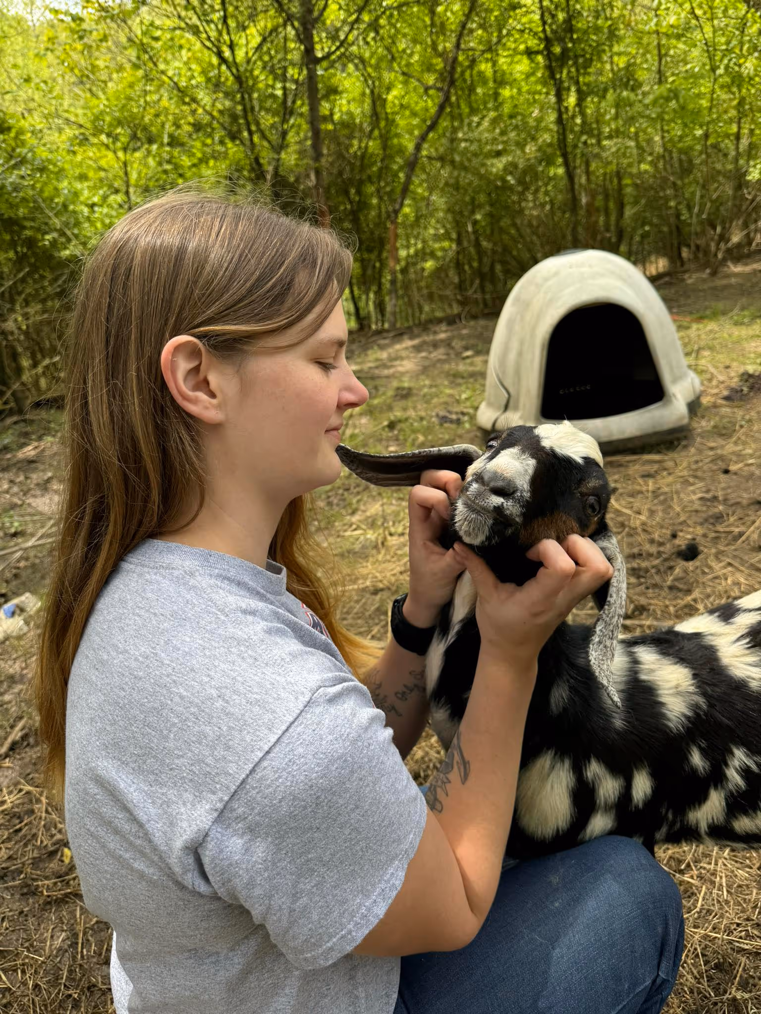 Kylea holding and petting a goat on the farm
