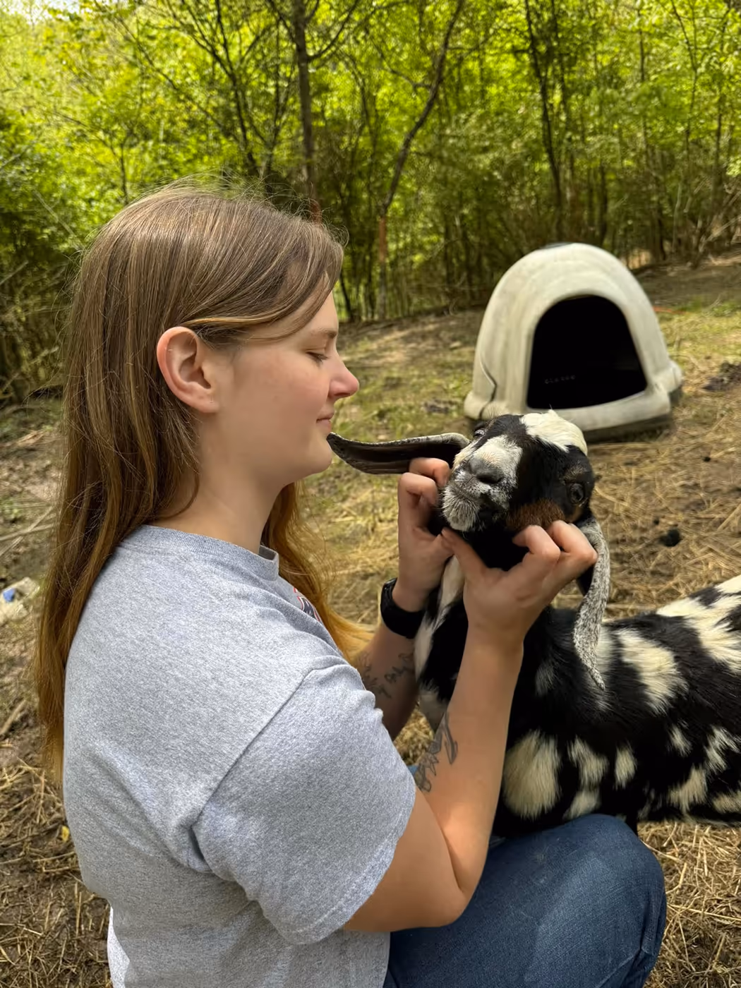Kylea holding and petting a goat on the farm