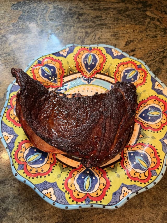 Raw lamb rib cut displayed on colorful decorative plate